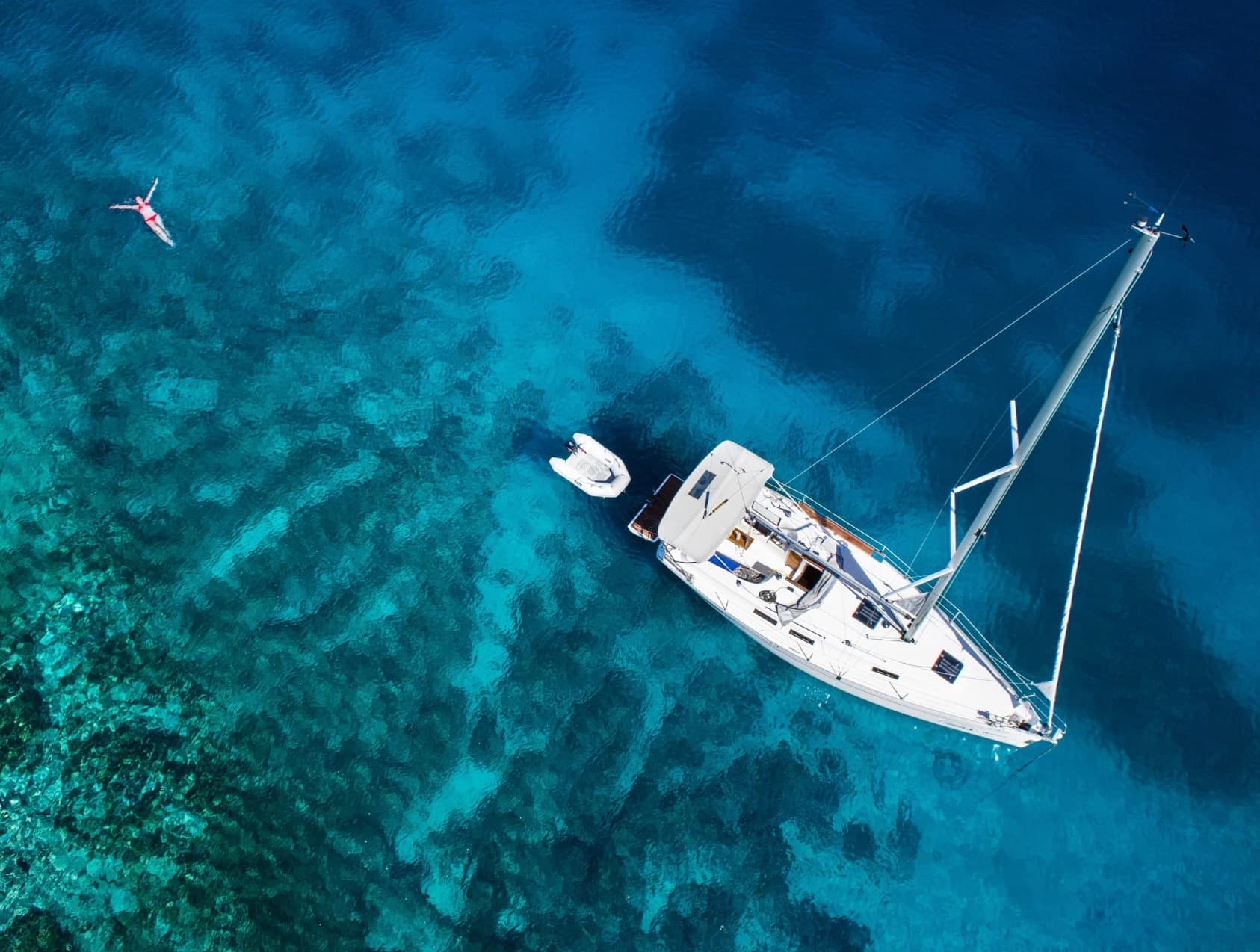Aerial view of yacht in crystal clear water